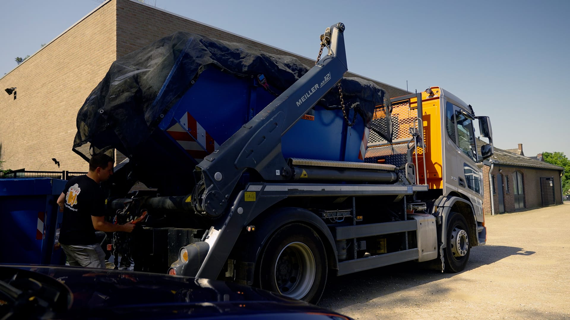 Kraanwagen van ContainerBuddy zet een afzetcontainer neer bij een woning